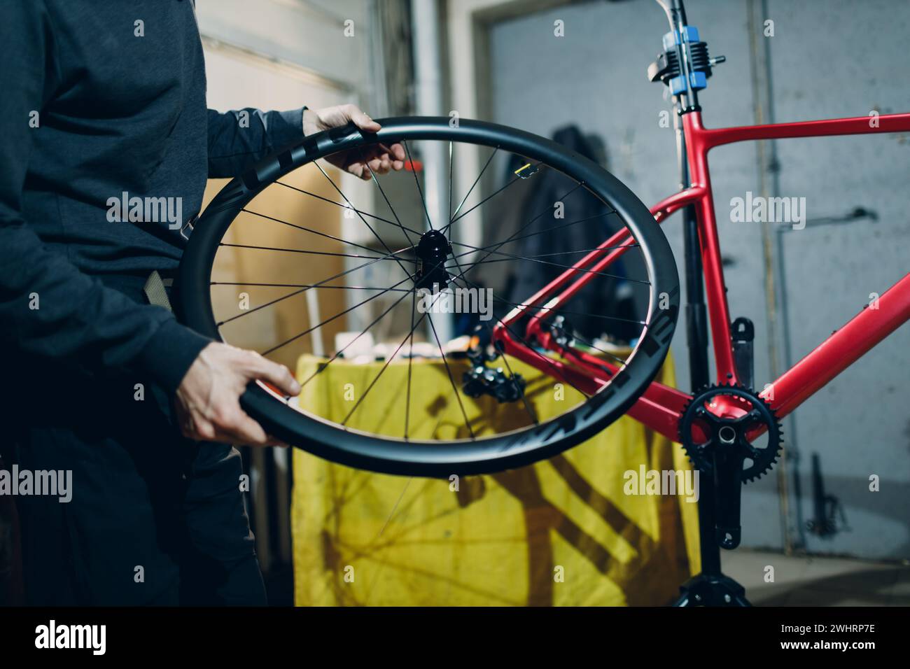 Mécanicien réparateur assemblant roue vélo sur mesure en atelier. Banque D'Images