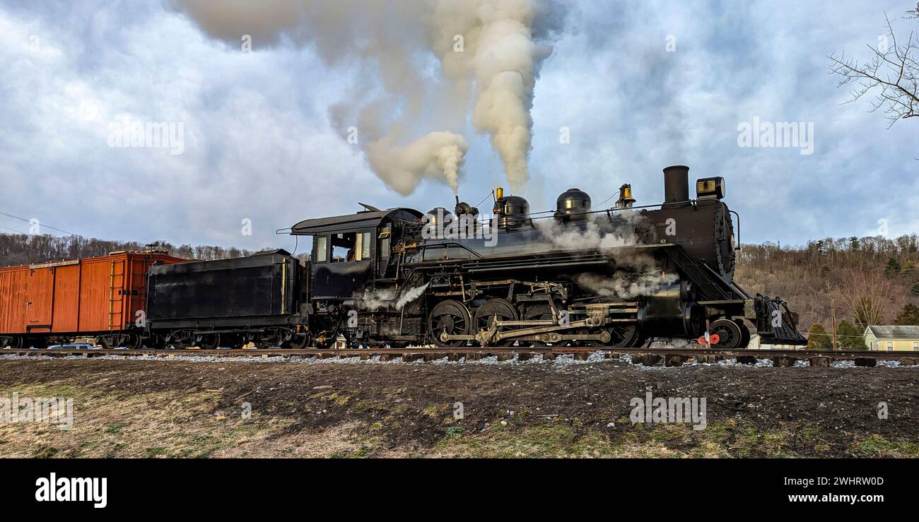 Vue d'une locomotive à vapeur à voie étroite restaurée soufflant de la fumée et de la vapeur Banque D'Images