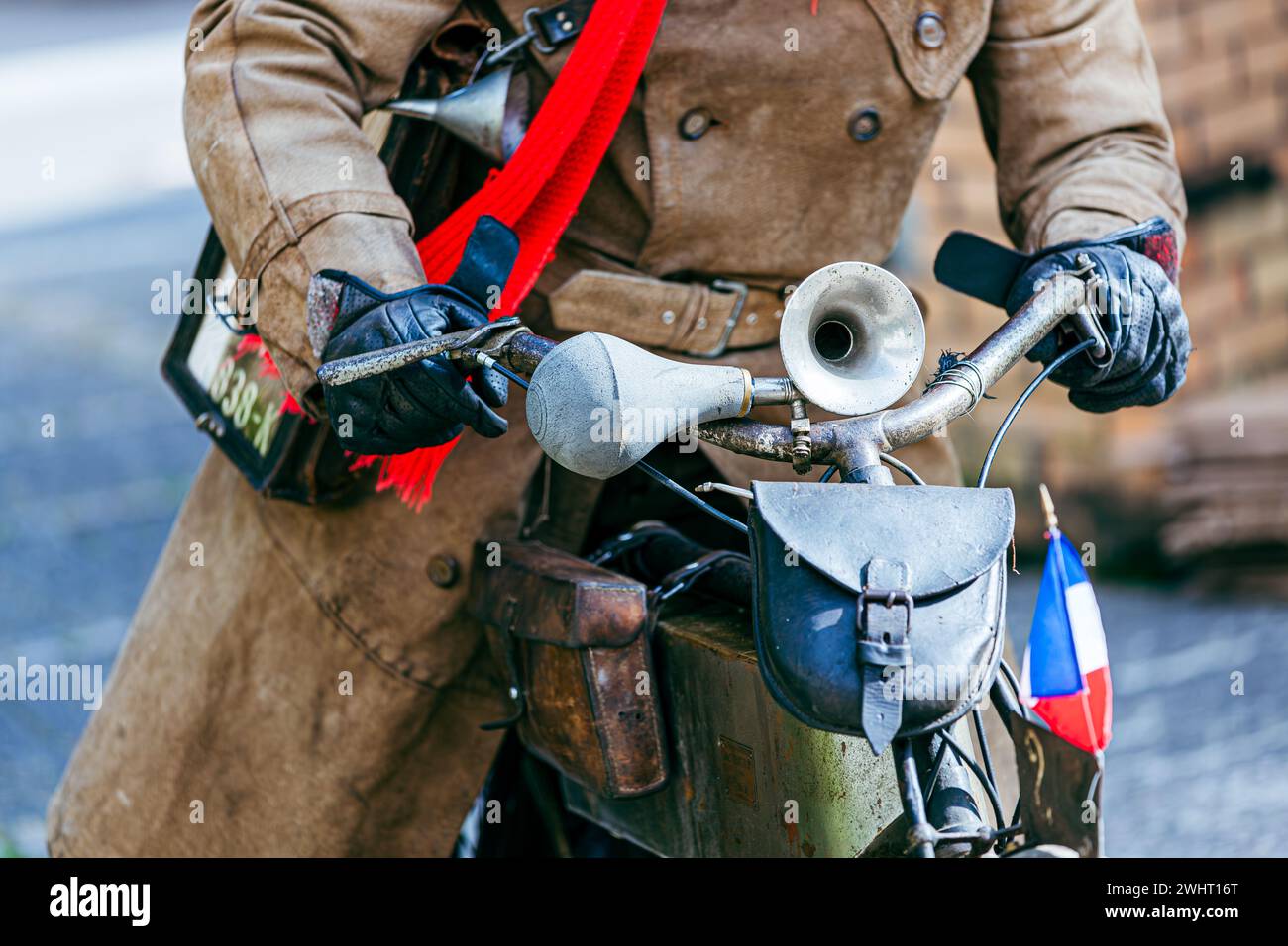 Gros plan d'un conducteur d'une vieille moto à entraînement par courroie CA 1903 avec des gants en cuir et Old-fashioned Banque D'Images