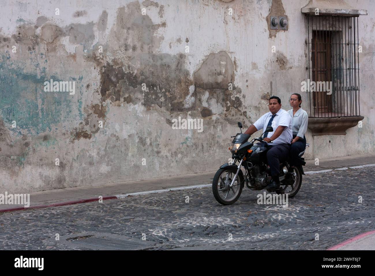 Antigua, Guatemala. Couple en moto, pas de casque. Banque D'Images