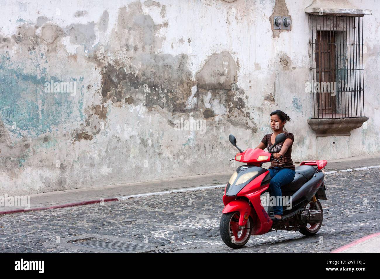Antigua, Guatemala. Jeune femme à moto, pas de Helmet. Banque D'Images