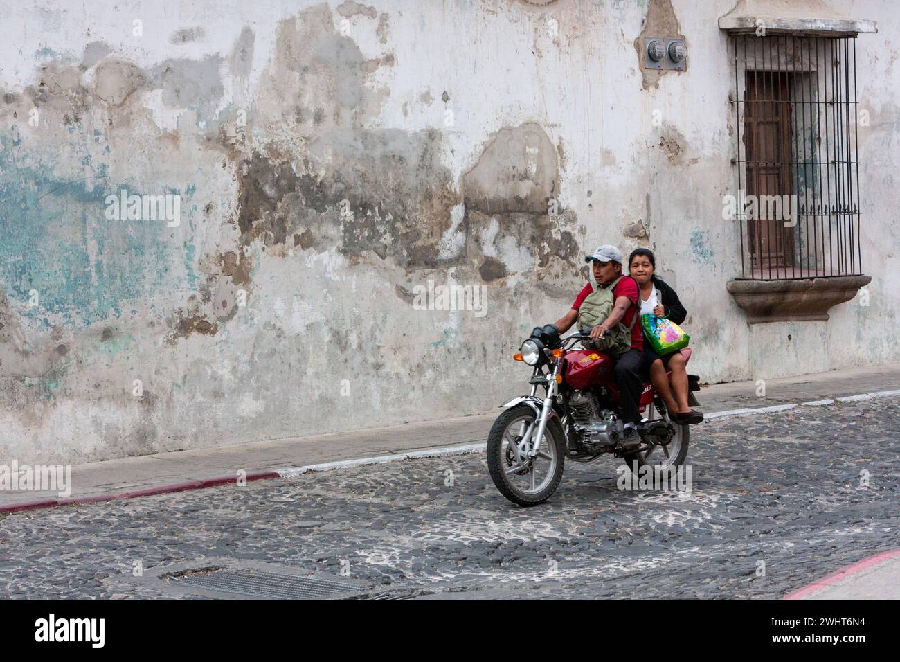 Antigua, Guatemala. Couple à moto, passager sans casque. Banque D'Images