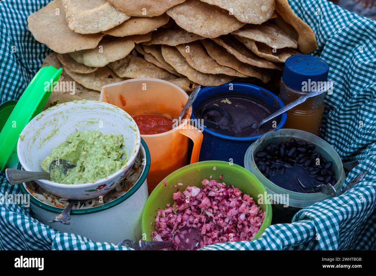 Antigua, Guatemala. Plateau à collation du vendeur de rue : guacamole, haricots, oignons, sauce chaude, tortillas. Banque D'Images