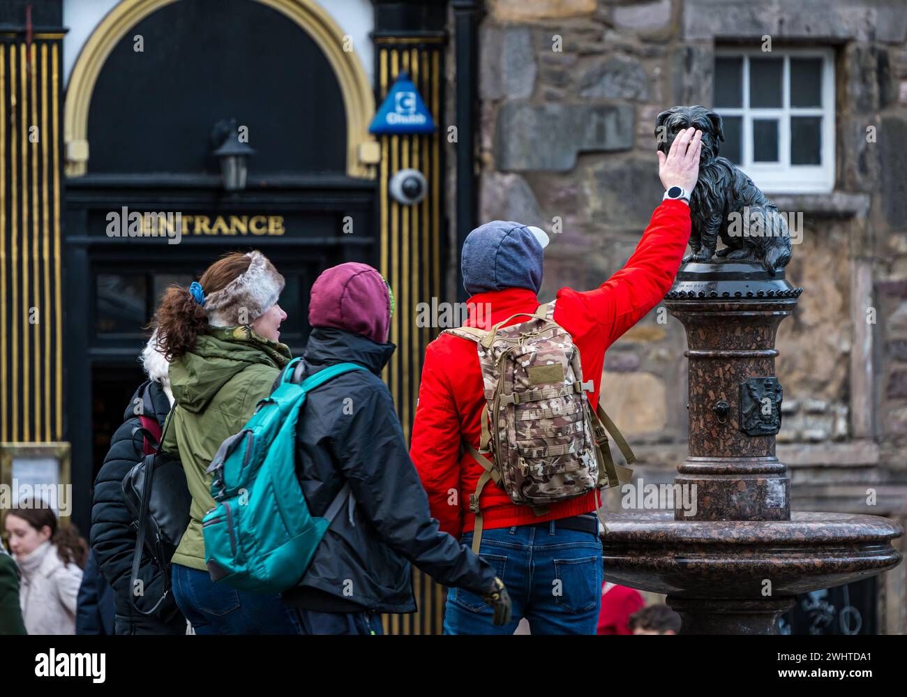 Touriste touchant le nez de la statue de chien Bobby de Greyfriar pour bonne chance, Édimbourg, Écosse, Royaume-Uni Banque D'Images