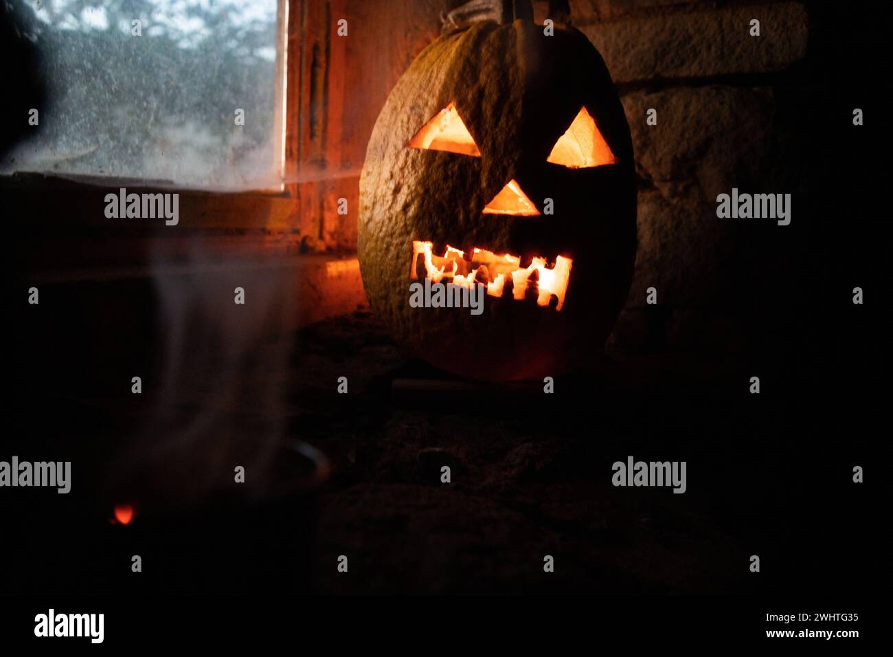 Citrouille d'Halloween effrayante dans la fenêtre la nuit Banque D'Images