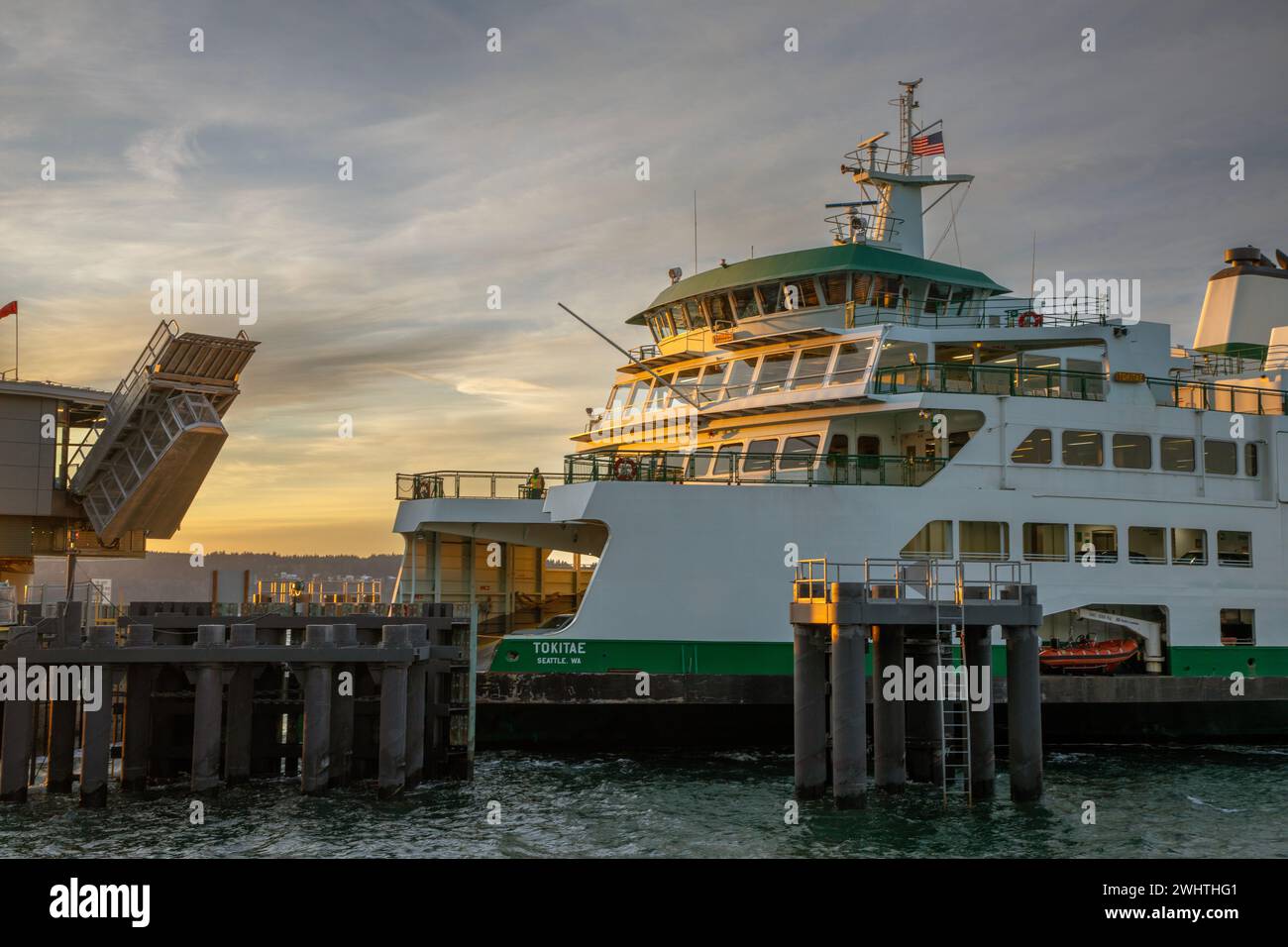 WA25043-00...WASHINGTON - Un ferry de passagers et de voitures de l'État de Washington avec une arrivée au coucher du soleil de Clinton au quai de Mukilteo. Banque D'Images