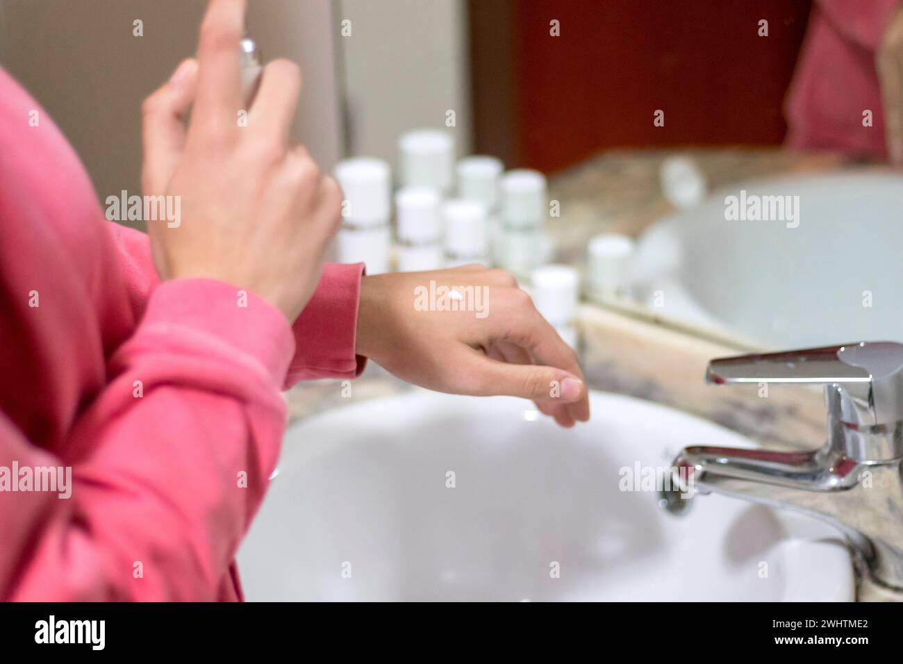 Recadrez l'image d'une jeune femme Relax, en appliquant une crème hydratante ou une lotion essentielle sur le dos de sa main. Femme appliquant la crème pour les mains après le bain. Seaso Banque D'Images
