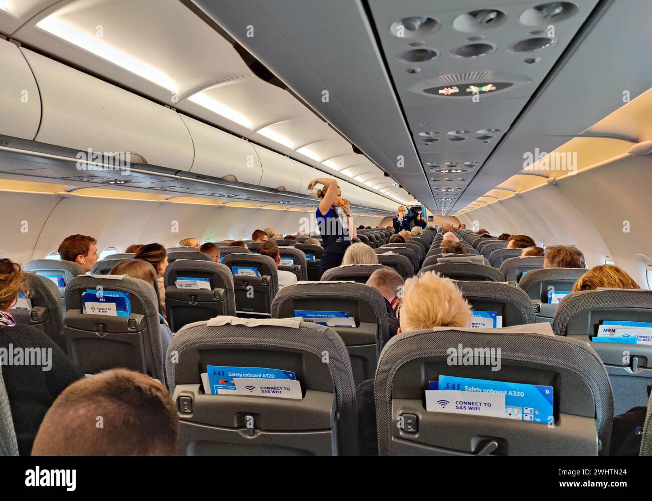 Passagers à l'intérieur d'un aéronef pendant la démonstration de sécurité par les agents de bord Banque D'Images