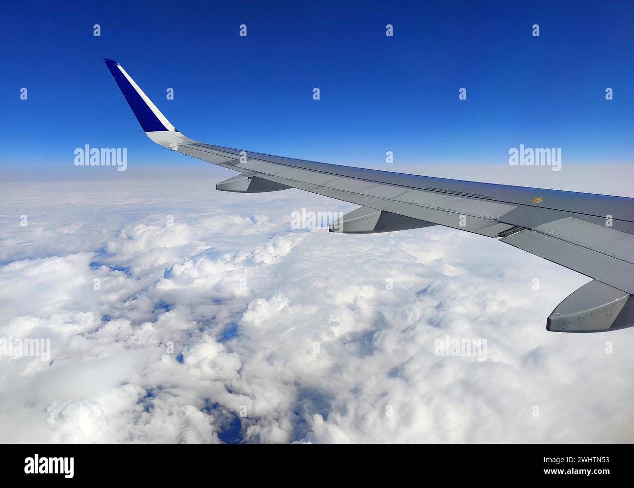 Vue de l'avion en volant sur une aile au-dessus des nuages avec un ciel bleu Banque D'Images