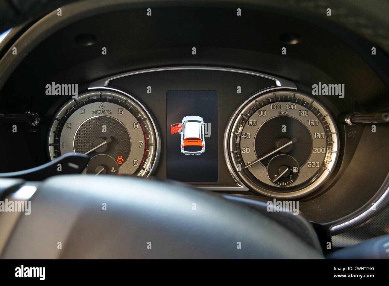 Icône d'avertissement de porte ouverte entre l'indicateur de vitesse et le compte-tours sur le tableau de bord du véhicule Banque D'Images