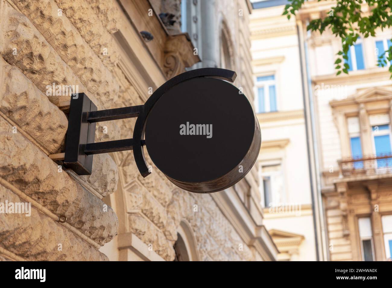 Le signe de logo de cercle noir propre se tient dans une rue de ville moderne, offrant un espace de premier choix pour la promotion du logo et une marque efficace Banque D'Images