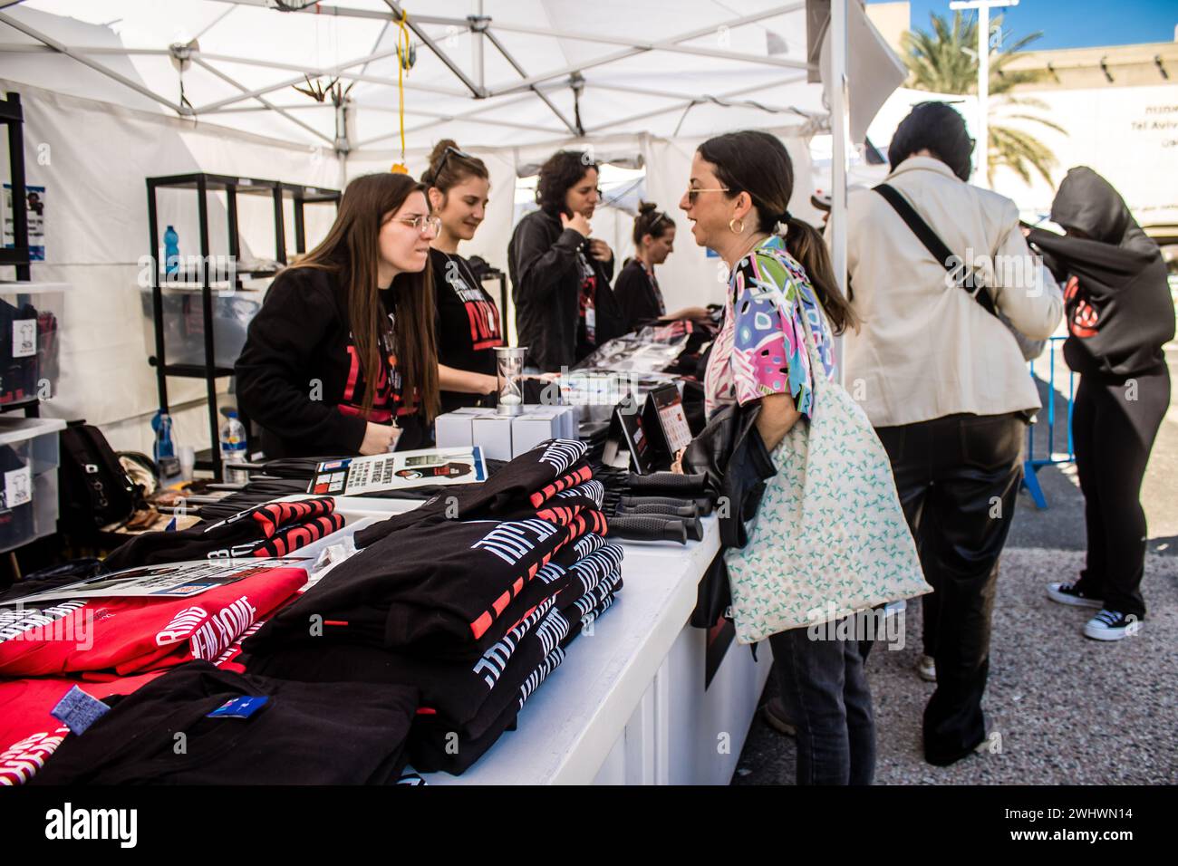 Tel Aviv, Israël - 11 février 2024 des bénévoles travaillent au stand Bring Them Home Now, où les visiteurs peuvent acheter des articles avec les recettes Banque D'Images