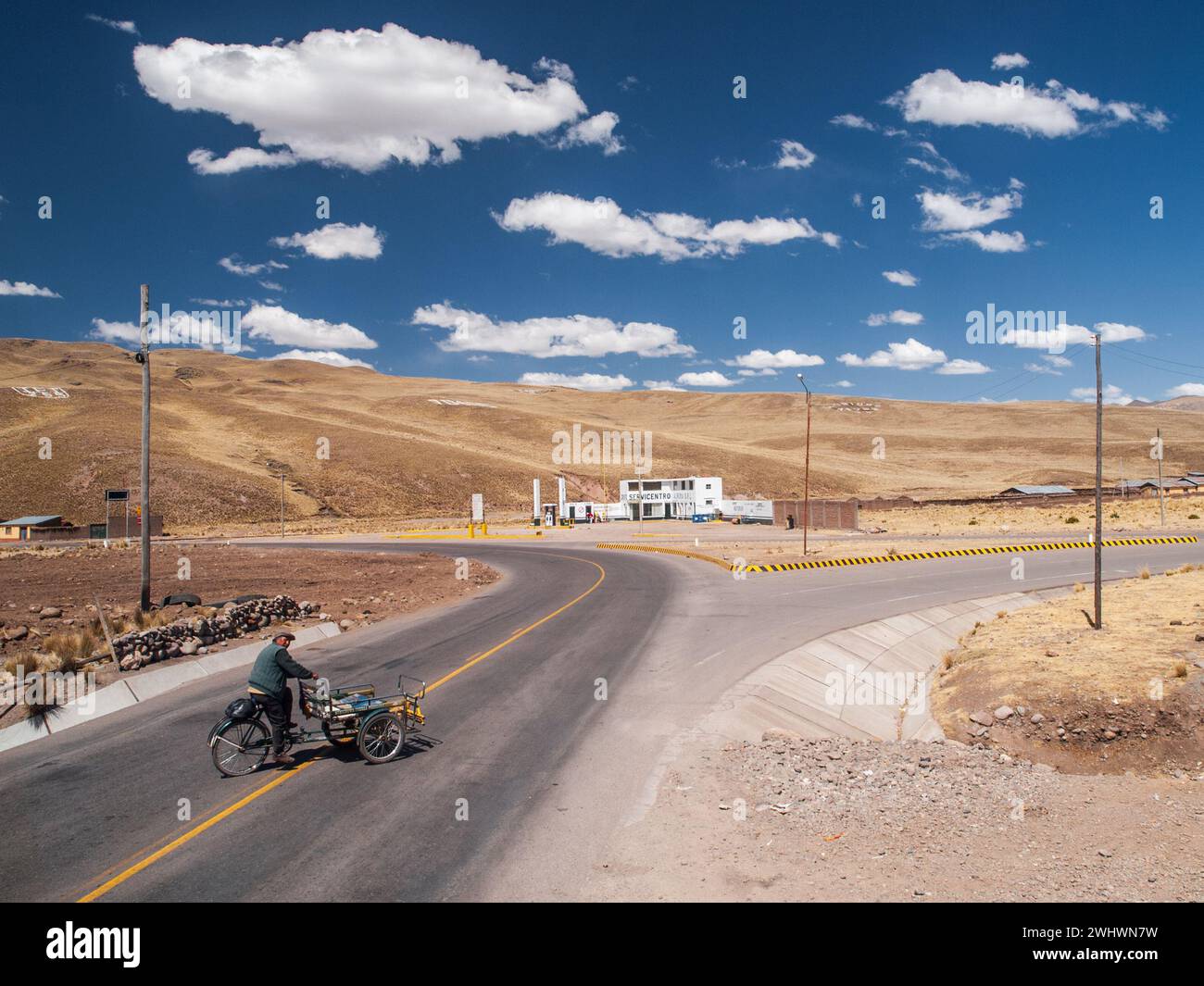 Homme péruvien traversant la route principale avec un vélo typique Banque D'Images