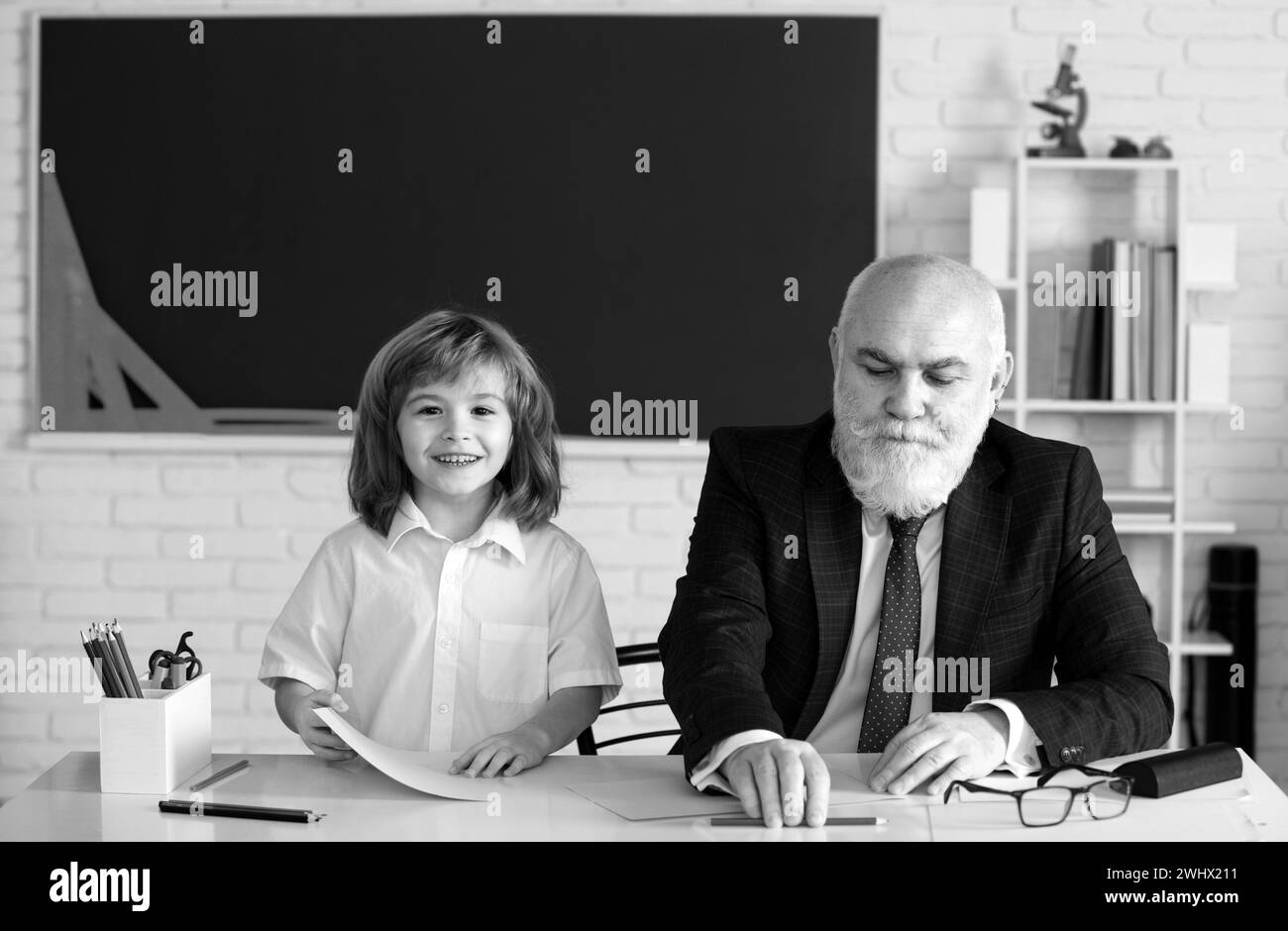 Joyeux enfant à l'école. Aide enseignant pour apprendre. Éducation, enseignement, école primaire. Banque D'Images