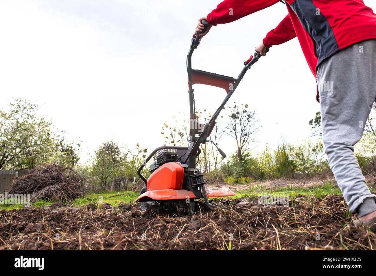 Motoblock dans le domaine du ménage. Travailler avec un cultivateur à moteur, labourer le sol pour semer des graines et planter des semis au début du printemps.. Banque D'Images