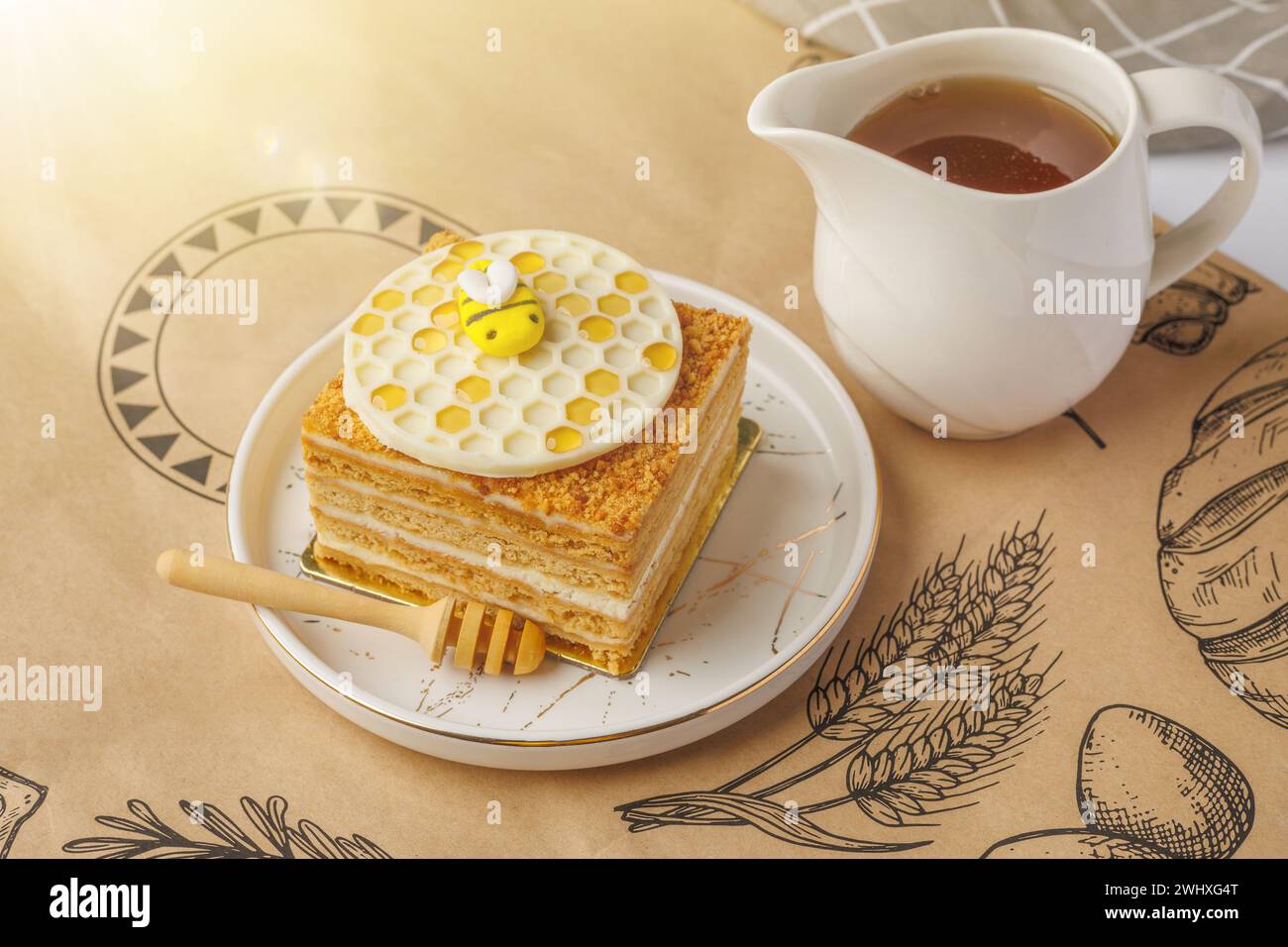 Napoléon gâteau avec tasse de miel sur nappe, gros plan Banque D'Images