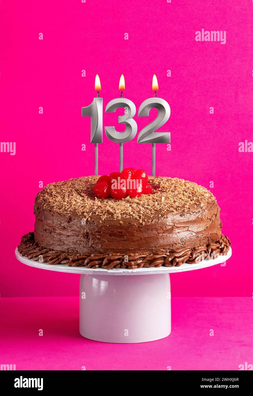 Numéro 132 bougie - gâteau au chocolat sur fond rose Banque D'Images