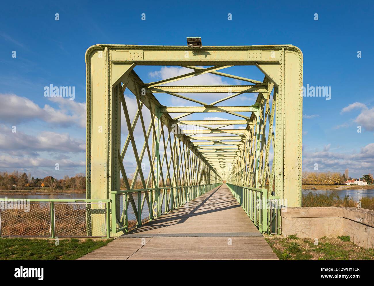 Long pont métallique peint en vert traversant la Loire contre un ciel bleu clair Banque D'Images