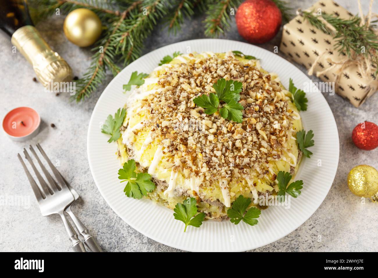 Apéritif de Noël. Salade du nouvel an de Noël avec pommes de terre, foie et noix sur la table de fête. Banque D'Images