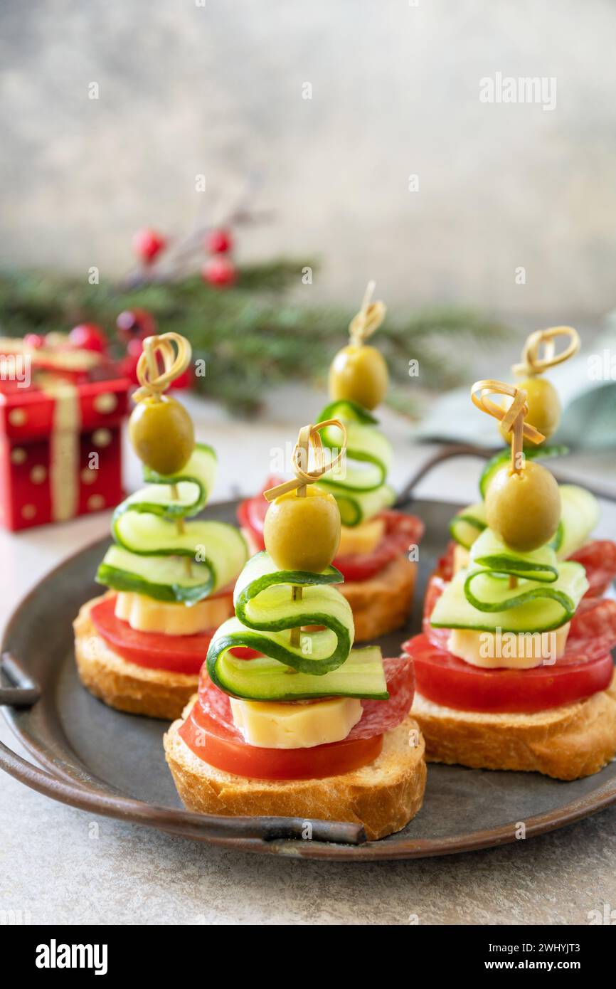 Hors-d'œuvre créatifs noël. Canapés arbre de Noël de salami, fromage, olives, tomates et concombres sur une baguette. Copier spac Banque D'Images