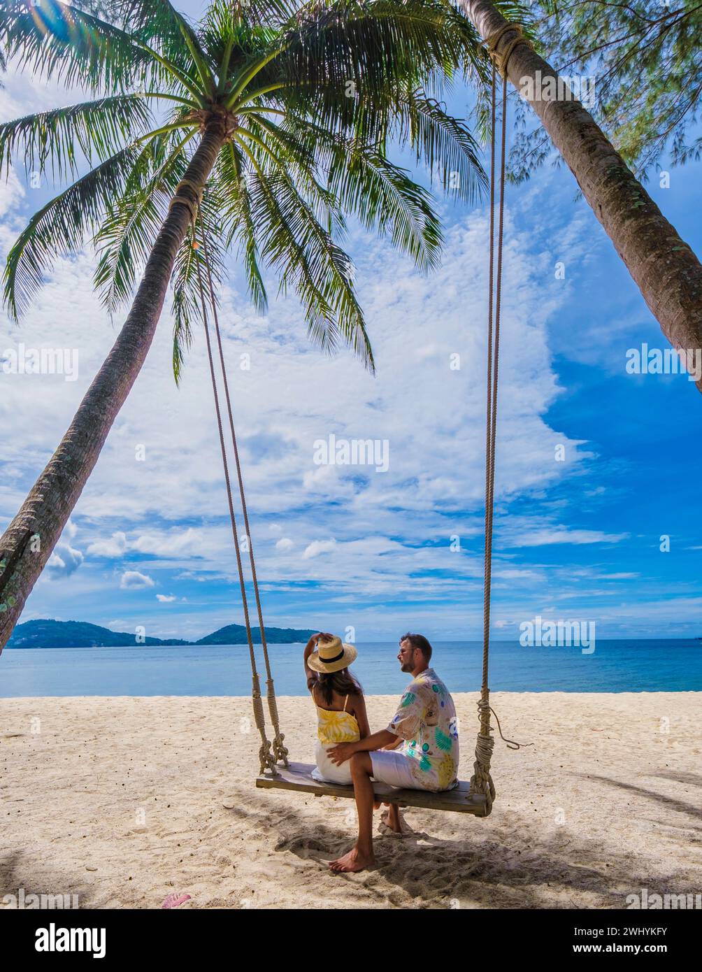 Couple sur une balançoire sur la plage avec des palmiers à Phuket Thaïlande Banque D'Images