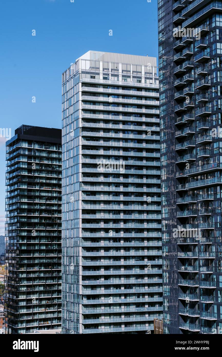 Bâtiments modernes de grande hauteur avec façades en verre sous un ciel bleu clair, réfléchissant la lumière du soleil. Banque D'Images