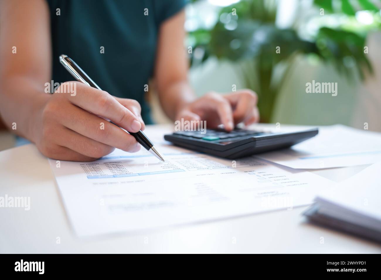 Femme d'affaires comptable analysant les graphiques d'investissement facture et appuyant sur les boutons de calculatrice sur les documents. Comptabilité Banque D'Images