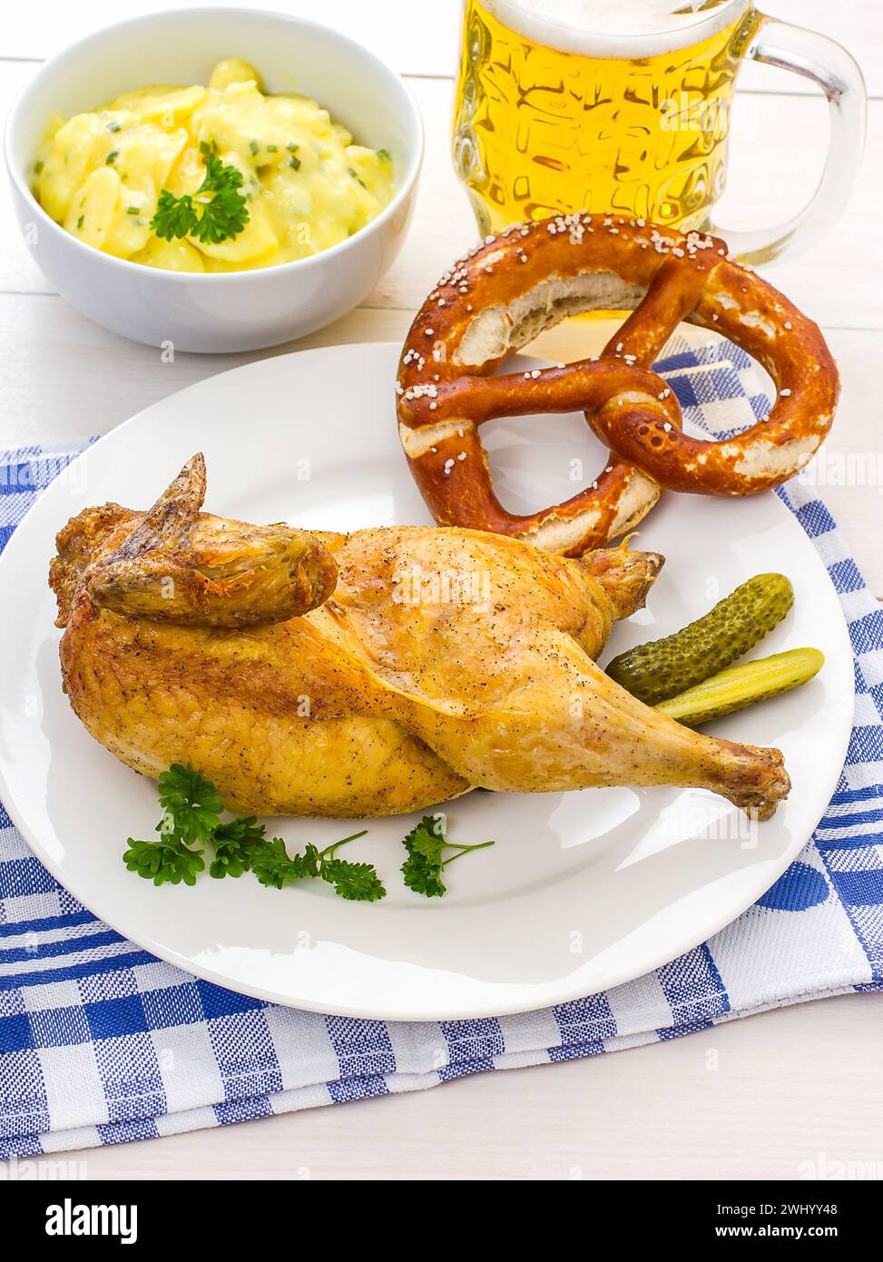 Poulet à moitié rôti, bière, bretzel et salade de pommes de terre Banque D'Images