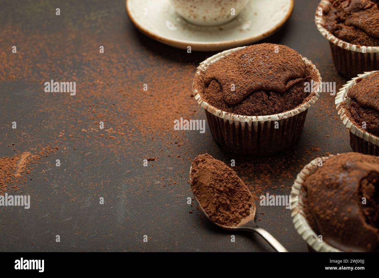 Muffins brunis au chocolat et au cacao avec cappuccino au café dans la vue d'angle de tasse sur fond de pierre rustique brun, dar doux fait maison Banque D'Images
