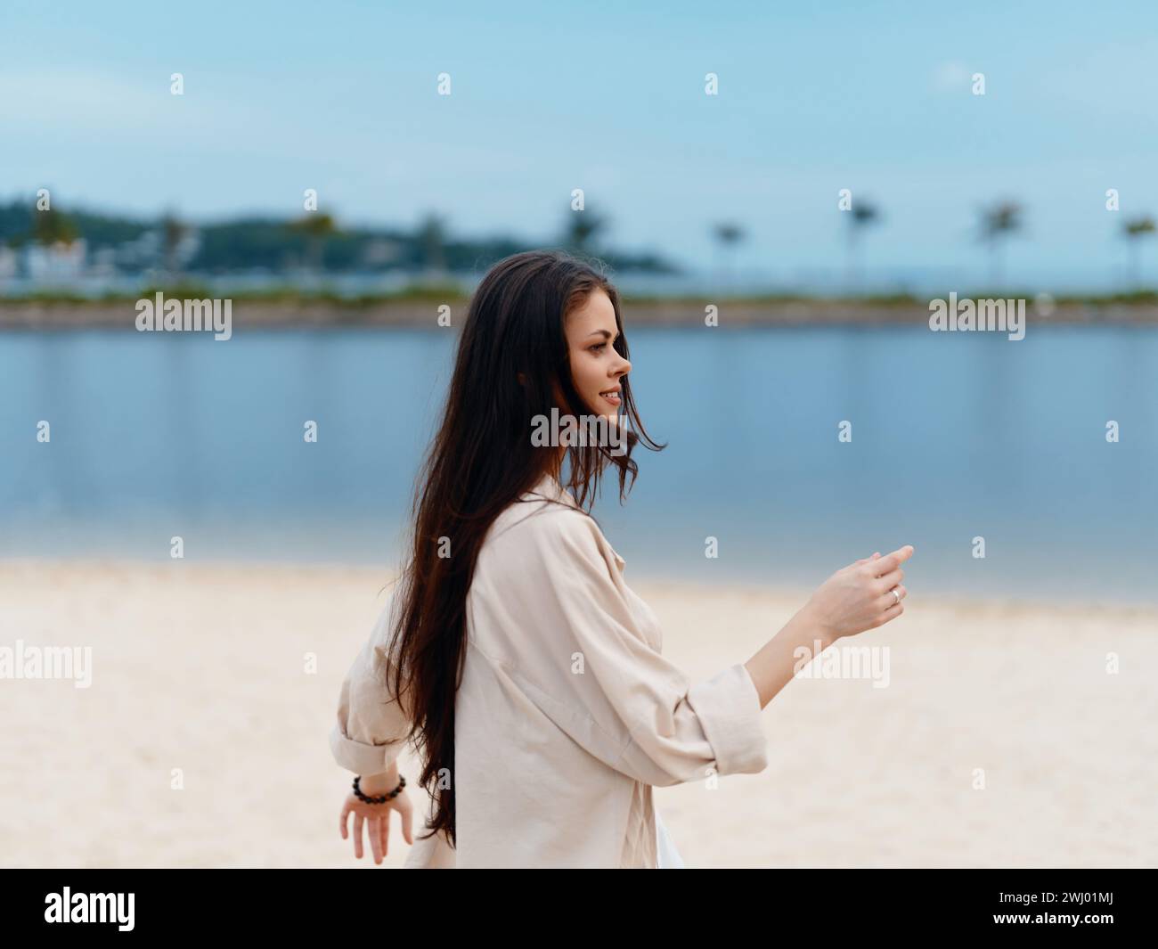 Beauté estivale sereine lors de vacances côtières : femme attrayante se relaxant sur une plage tropicale, profitant de l'océan rafraîchissant et du soleil chaud. Banque D'Images