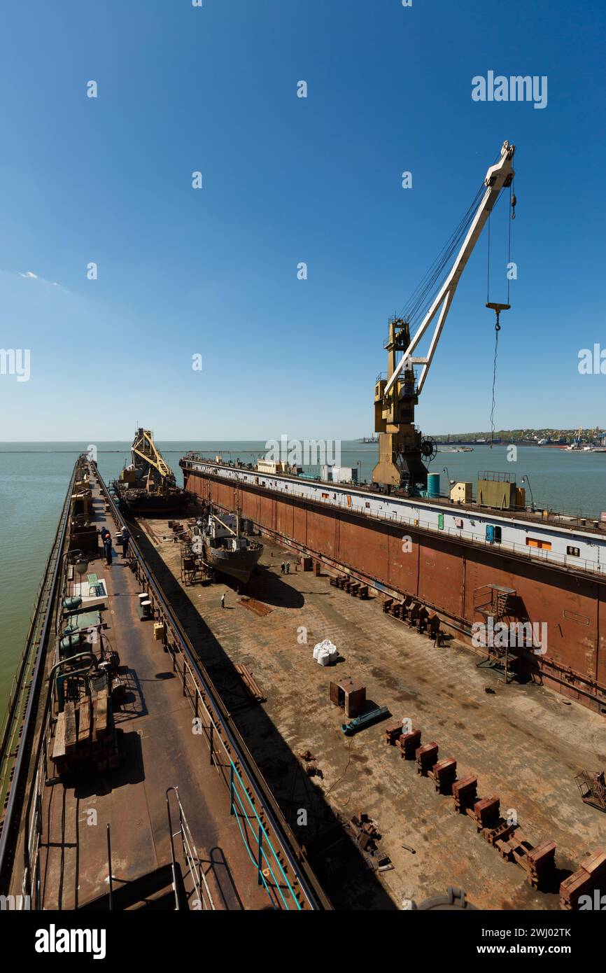 Grand quai flottant, station de réparation de navire maritime avec grue le jour ensoleillé. Cale sèche vide, infrastructure de l'industrie maritime. Entretien des expéditions en bord de mer Banque D'Images