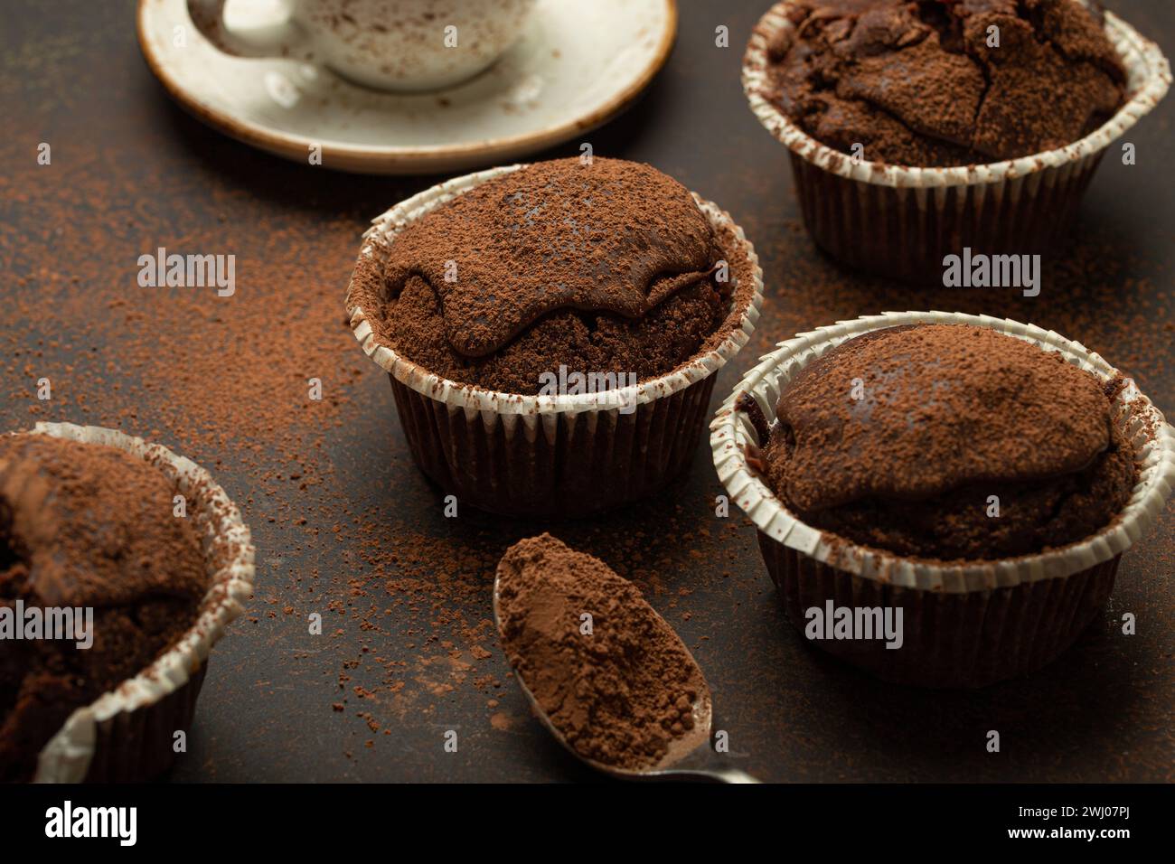 Muffins brunis au chocolat et au cacao avec cappuccino au café dans la vue d'angle de tasse sur fond de pierre rustique brun, dar doux fait maison Banque D'Images