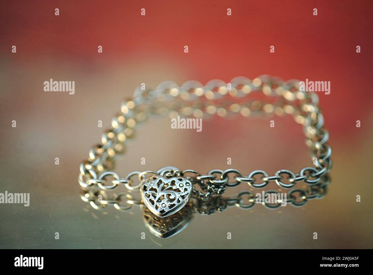 Bracelet breloque coeur en argent avec chaîne, élégamment affiché sur une table Banque D'Images