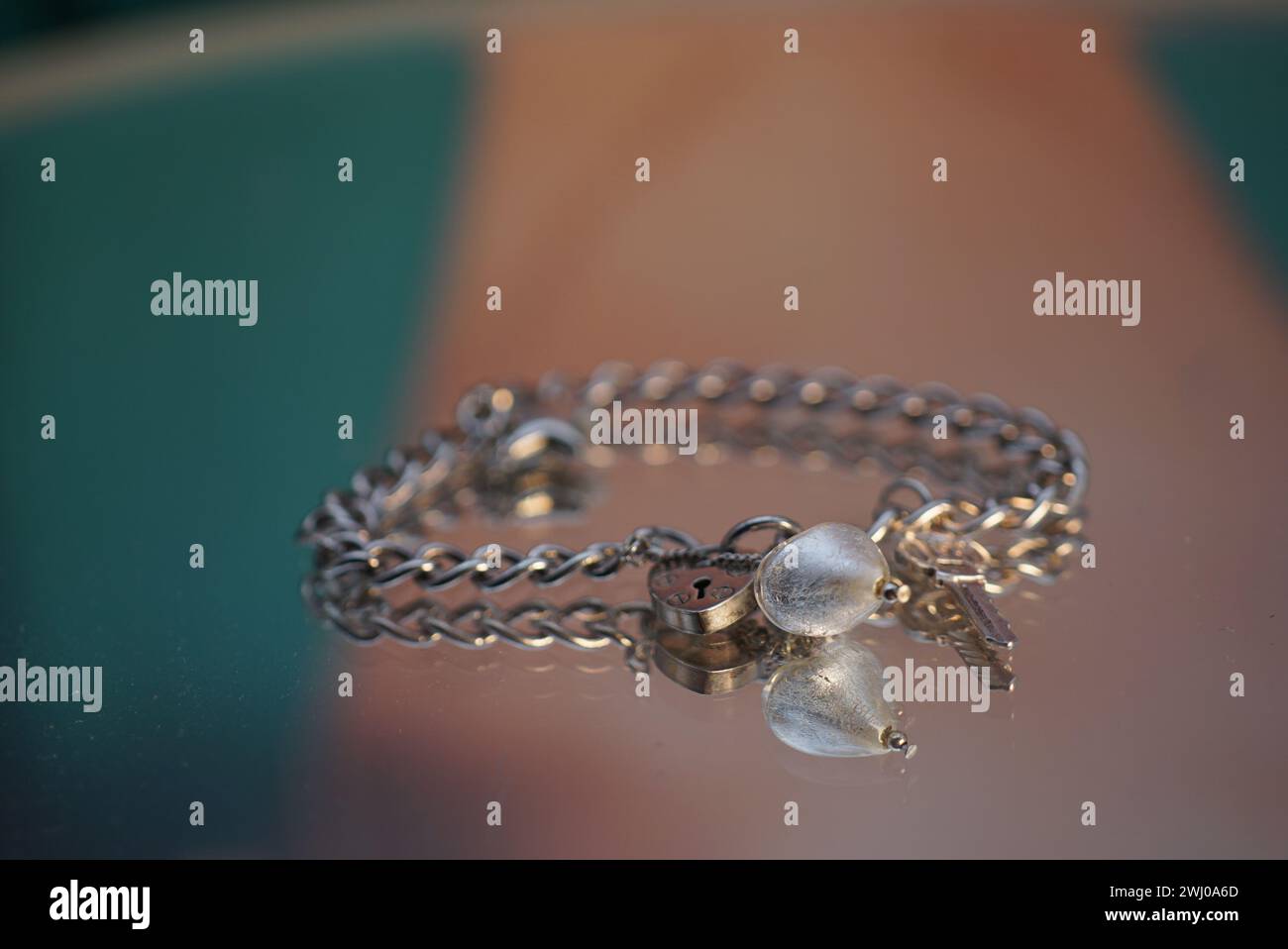 Bracelet breloque en argent avec deux perles, élégamment placé sur une table Banque D'Images