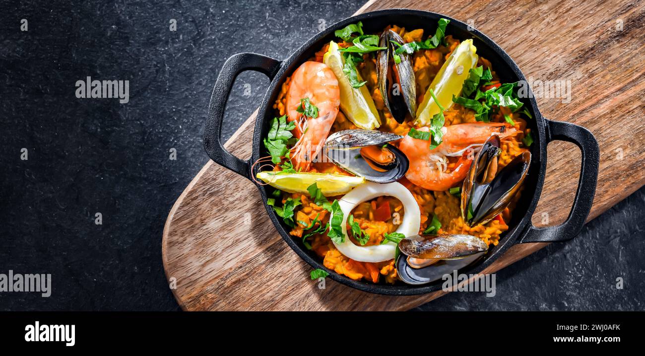 Paella de fruits de mer servie dans une poêle en fonte. Banque D'Images