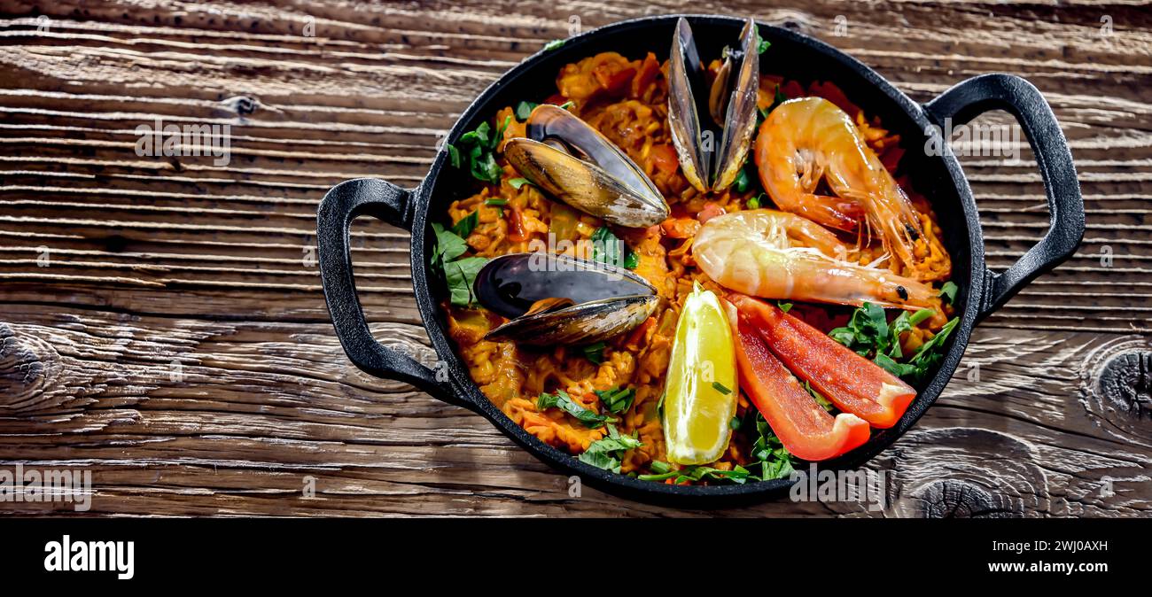 Paella de fruits de mer servie dans une poêle en fonte. Banque D'Images