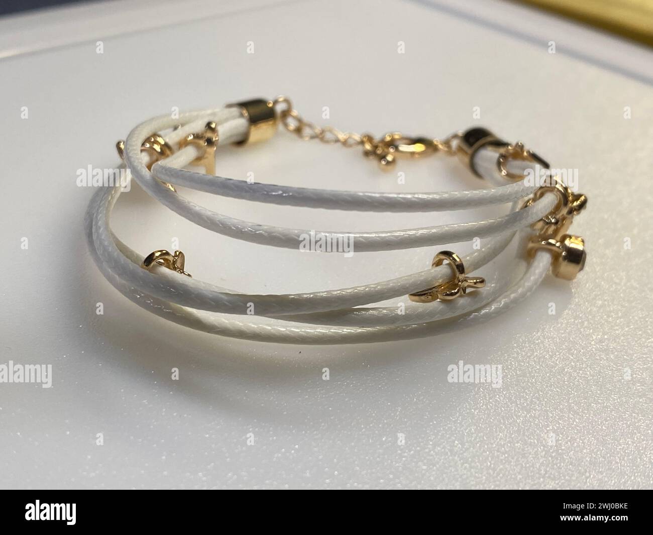 Bracelets empilés en cuir et métal ornés de perles et de touches dorées Banque D'Images