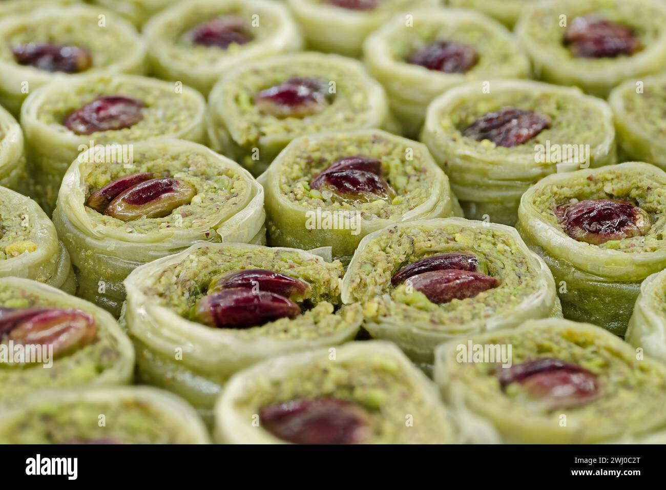 Dessert turc traditionnel, baklava, rempli de pistaches écrasées, décoré de noix entières, fond de nourriture abstraite Banque D'Images