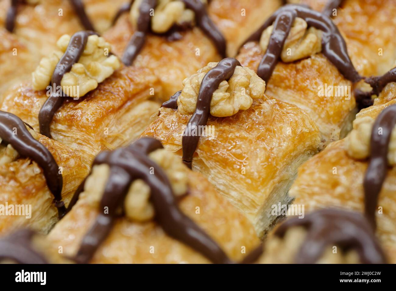 Dessert turc traditionnel, baklava, décoré avec des noix et du chocolat, fond de nourriture abstraite Banque D'Images