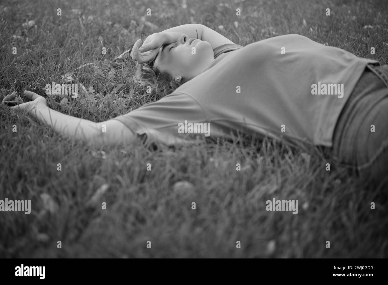 Portrait d'une femme heureuse allongée dans l'herbe dans un parc en été dans la ville dans la nature. jardin et femme personne ou modèle extérieur avec liberté, bonheur, style. Photo de haute qualité Banque D'Images