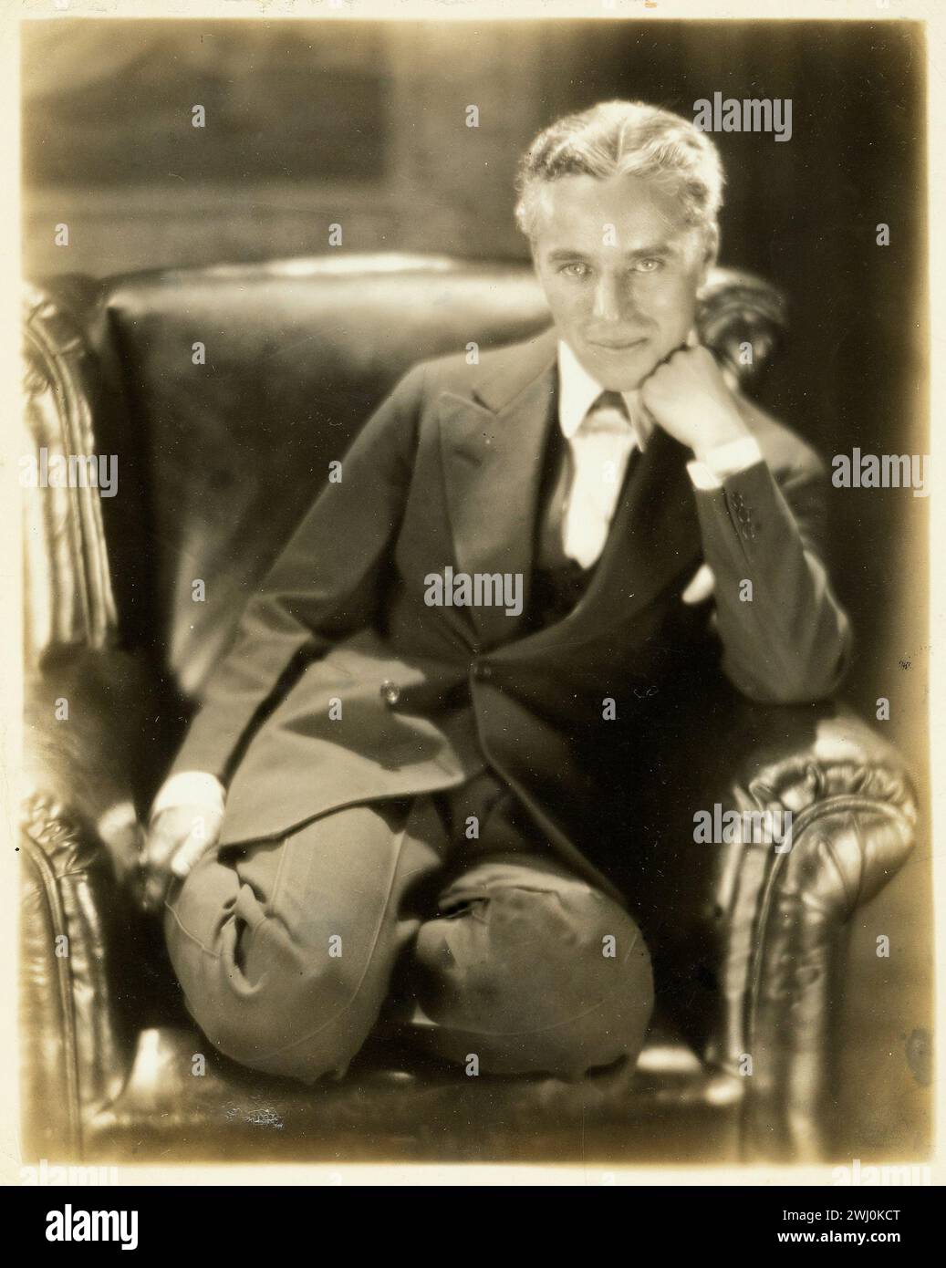 Portrait de Charlie Chaplin sur une chaise, vers 1920-1930s Banque D'Images