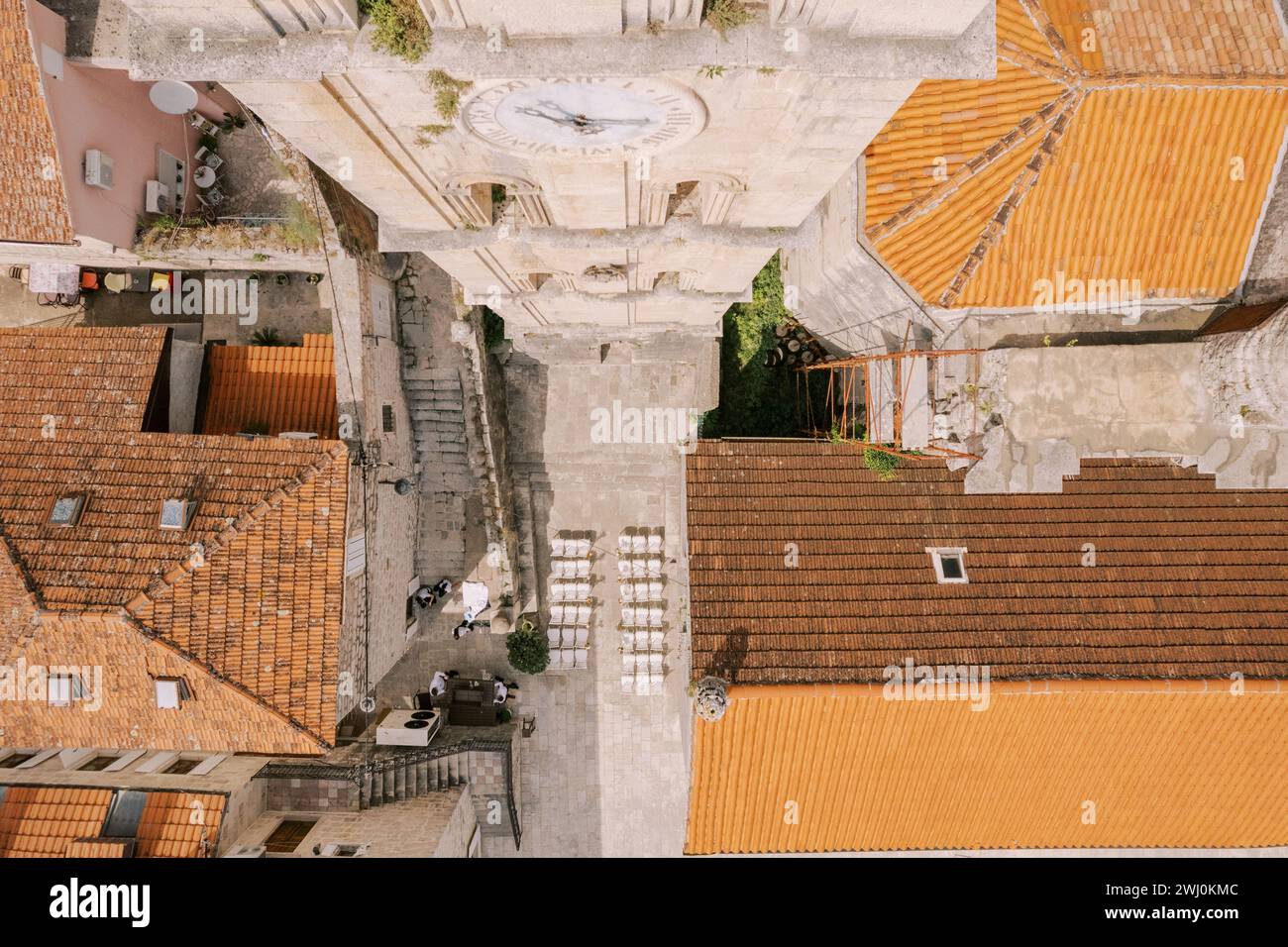 Des rangées de chaises blanches se dressent dans la rue près du clocher de l'église Saint-Nicolas. Perast, Monténégro. Vue de dessus Banque D'Images