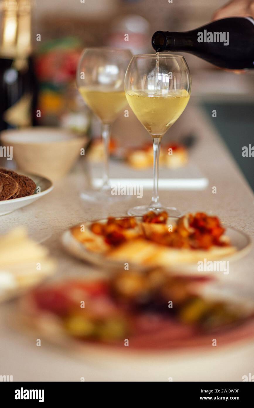 Deux verres de champagne frais et des assiettes avec diverses collations sur une table Banque D'Images