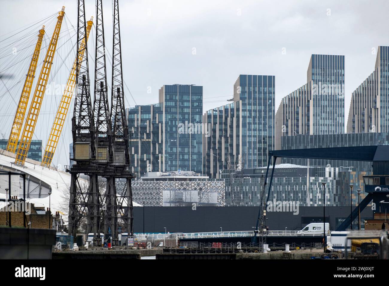 Nouveaux immeubles de grande hauteur à North Greenwich vus du cœur du quartier financier de Canary Wharf à travers South Dock le 6 février 2024 à Londres, Royaume-Uni. Le O2 aka Millennium Dome est vu comme le sont les anciennes grues Stothert & Pitt toujours debout là où elles faisaient partie des quais de travail dans les Docklands. Banque D'Images