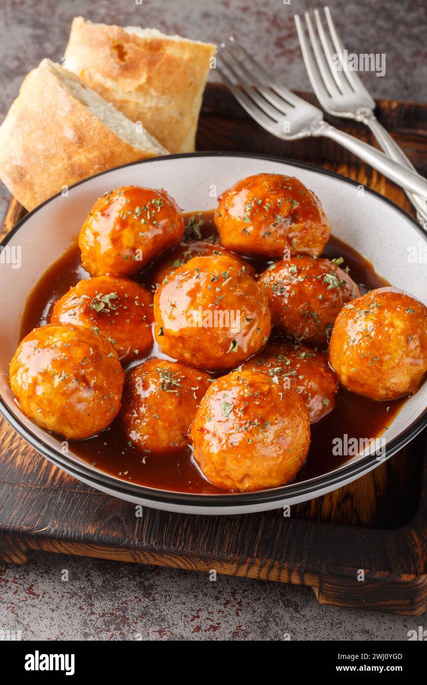 Chipotle Honey Meatballs sont l'apéritif mexicain sucré et épicé parfait en gros plan sur le bol sur la table. Vertical Banque D'Images