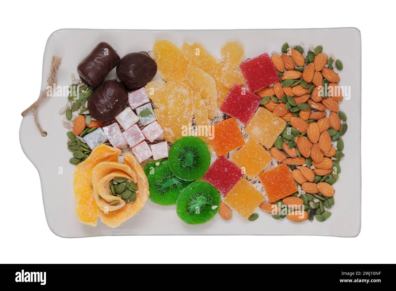 Desserts sucrés dans l'assiette pour les vacances. Marmelade, fruits confits, mangue, kiwi, noix, graines, bonbons au chocolat et délice turc dans une assiette. Top vie Banque D'Images
