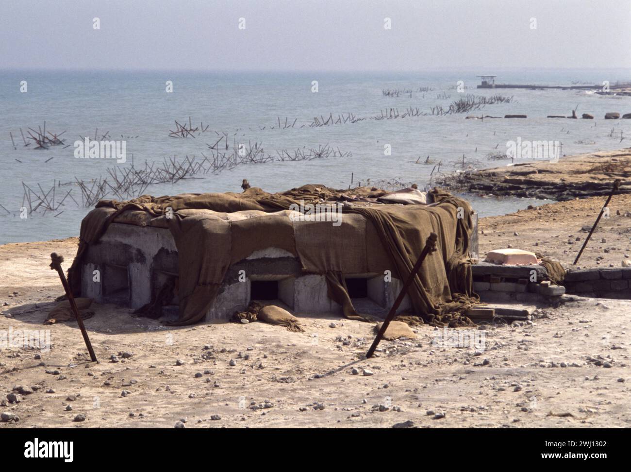 10 mars 1991. Un bunker irakien abandonné surplombant les défenses barbelées sur le front de mer à Koweït City. Banque D'Images