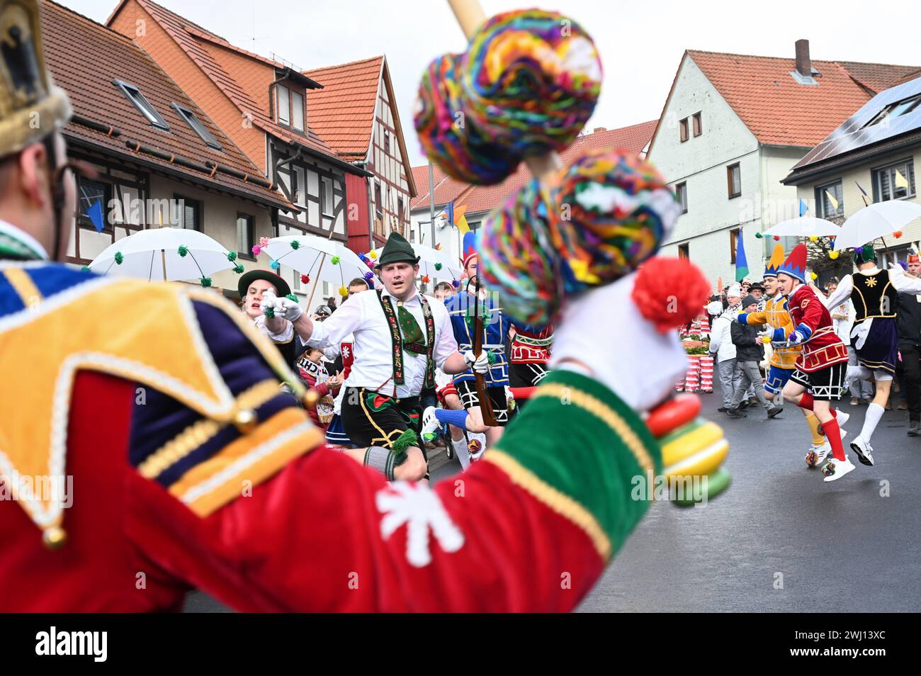 Herbstein, Allemagne. 12 février 2024. Le couple tyrolien est en action dans ses costumes traditionnels colorés au Herbstein Springerzug. Les tailleurs de pierre tyroliens ont apporté la tradition à Herbstein au XVIIe siècle. Plus de 50 chars ont pris part au traditionnel défilé Rose Monday dans la ville du district de Vogelsberg. Crédit : Uwe Zucchi/dpa/Alamy Live News Banque D'Images