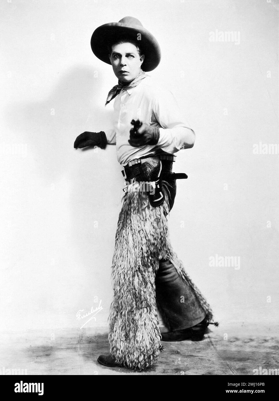 La star occidentale Hoot Gibson dans le rôle de Duke Travis dans Shootin' for Love (Universal, 1923). Portrait photo - tenue de cow-boy, tenant le revolver Banque D'Images