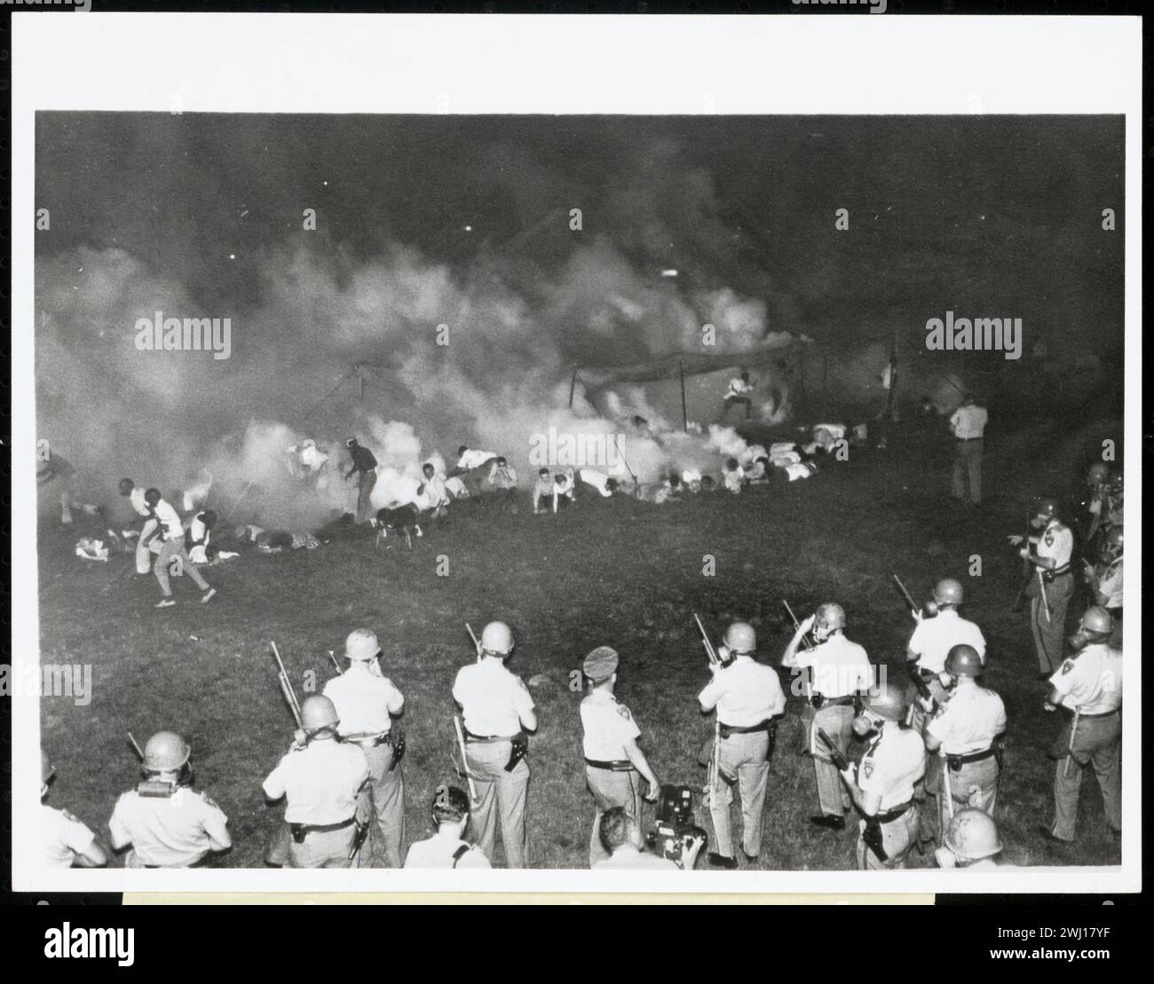 ÉMEUTE DE LA COURSE DE TULSA (31 mai et 1er juin 1921) : la police disperse les manifestants avec des gaz lacrymogènes . Photographie d'Afro-Américains qui tentent de s'échapper de leurs tentes qui viennent d'être attaquées au gaz lacrymogène par des soldats qui se tiennent alignés avec des masques à gaz et des fusils au premier plan. Banque D'Images